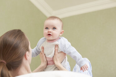 Women holding up baby daughter - CUF08621