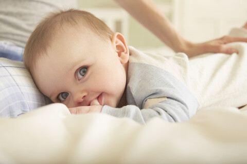 Porträt eines kleinen Mädchens, das mit seiner Mutter auf dem Bett liegt, lizenzfreies Stockfoto