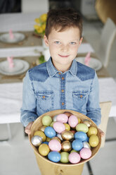 Porträt eines Jungen, der eine Schale mit bunten Ostereiern hält - CUF08650