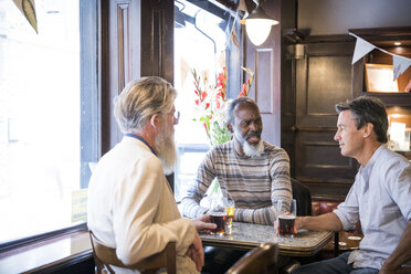 Three mature men, sitting together in pub, talking - CUF08689