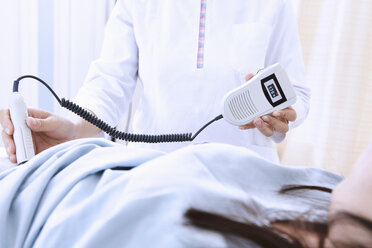 Sonographin gibt schwangere Patientin Ultraschalluntersuchung - CUF08736