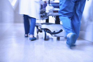 Abgeschnittene Rückansicht von Ärzten, die eine Bahre im Korridor schieben - CUF08745