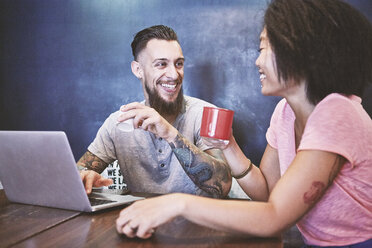 Multi ethnic hipster couple in cafe using laptop, Shanghai French Concession, Shanghai, China - CUF08846