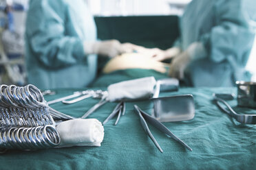 Nahaufnahme von chirurgischen Instrumenten mit Chirurgen, die eine Operation im Operationssaal der Entbindungsstation durchführen - CUF08853