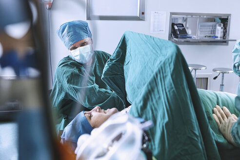 Chirurgen bereiten eine Patientin im Operationssaal der Entbindungsstation auf die Operation vor - CUF08854
