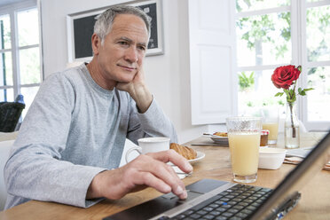 Man using laptop while having breakfast - CUF08871