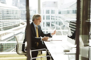 Businessman reading and analysing report, London, UK - CUF08979