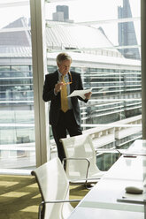 Businessman reading and analysing report, London, UK - CUF08982