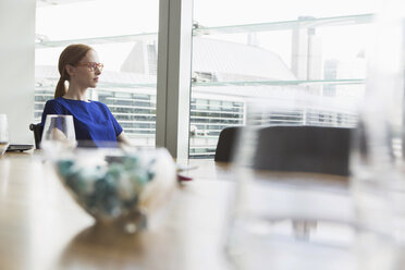 Businesswoman looking out of office window, London, UK - CUF09002