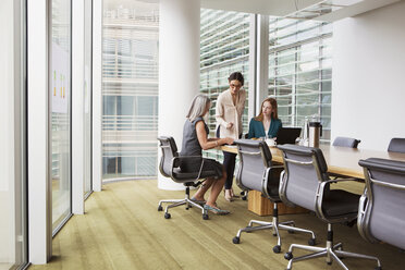 Businesswomen preparing presentation in meeting room - CUF09012