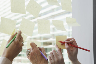 Geschäftsfrauen beim Brainstorming auf einem Glasfenster - CUF09023