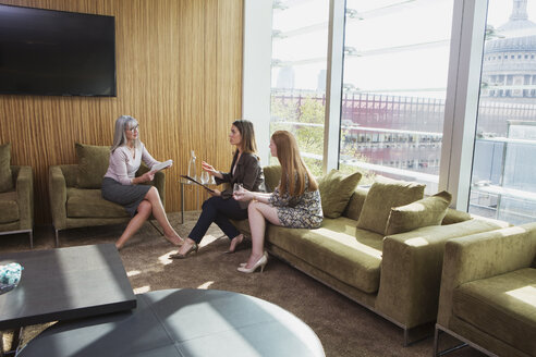 Geschäftsfrauen treffen sich auf einem Bürosofa, London, UK - CUF09036