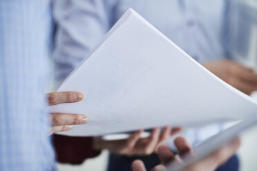 Cropped view of colleagues holding paperwork - CUF09073