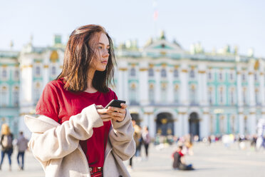 Russland, St. Petersburg, junge Frau mit Smartphone in der Stadt - WPEF00252