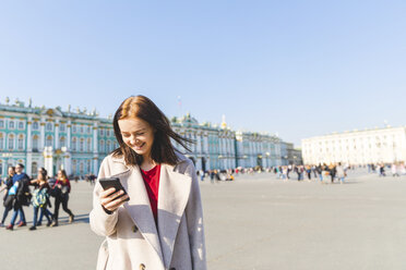 Russland, St. Petersburg, junge Frau mit Smartphone in der Stadt - WPEF00254