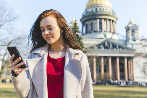 Russland, St. Petersburg, junge Frau mit Smartphone in der Stadt - WPEF00255