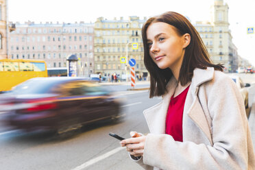 Russland, St. Petersburg, junge Frau mit Smartphone in der Stadt - WPEF00260