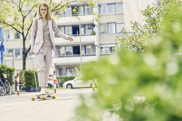 Geschäftsfrau fährt mit dem Skateboard zur Arbeit - CUF09219