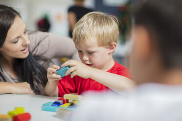 Vorschullehrerin spielt mit Kind im Kindergarten - ZEF15428