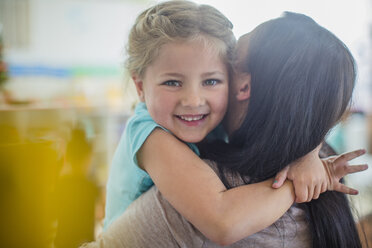 Porträt eines lächelnden Mädchens im Kindergarten, das eine Vorschullehrerin umarmt - ZEF15448