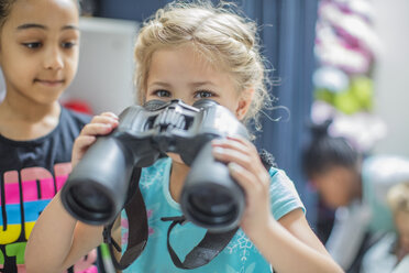 Mädchen hält Fernglas im Kindergarten - ZEF15449