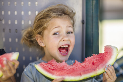 Porträt eines glücklichen Mädchens, das im Kindergarten eine Wassermelone isst, lizenzfreies Stockfoto