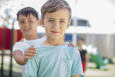 Porträt eines lächelnden Jungen mit Freunden auf dem Spielplatz im Kindergarten - ZEF15478