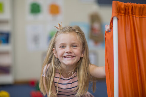Porträt eines glücklichen Mädchens mit Miniaturkrone im Kindergarten - ZEF15483