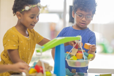 Junge und Mädchen spielen mit einer Spielzeugwaage im Kindergarten - ZEF15484