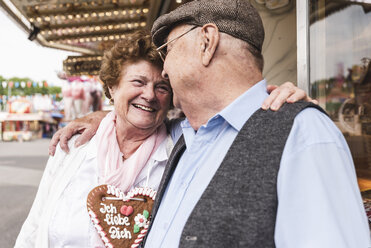 Happy senior couple with gingerbread heart on fair - UUF13741