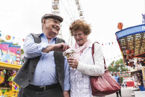 Senior couple having fun together on fair - UUF13746