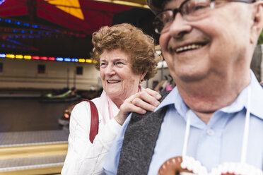 Porträt einer älteren Frau, die sich zusammen mit ihrem Mann auf dem Jahrmarkt vergnügt - UUF13754