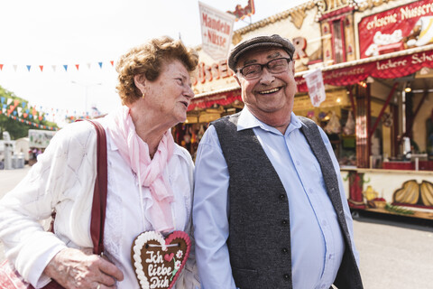 Älteres Paar hat Spaß auf dem Jahrmarkt, lizenzfreies Stockfoto