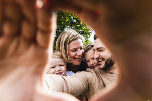 Happy family behind finger frame - UUF13764