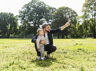 Father talking to son in a park - UUF13802