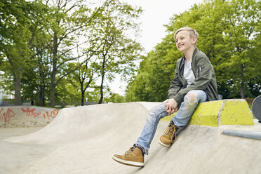 Lachender Junge schaut im Skatepark zur Seite - PDF01639