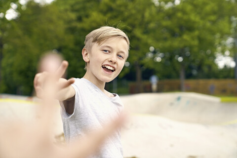 Junge macht Siegeszeichen im Skatepark, lizenzfreies Stockfoto