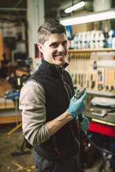 Porträt eines lächelnden Mechanikers in seiner Werkstatt - RAEF02043