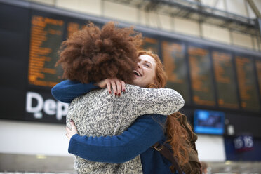 Two young women hugging at train station - CUF09286