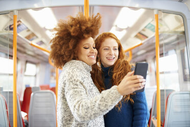 Freunde machen Selfie mit Handy im Zug, London - CUF09308