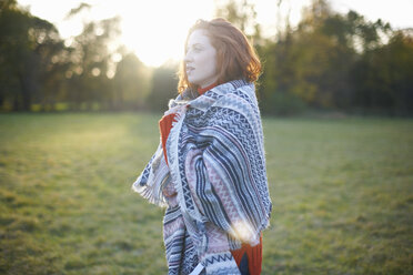 Young woman in rural setting, wrapped in blanket - CUF09332