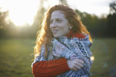 Young woman in rural setting, wrapped in blanket - CUF09333