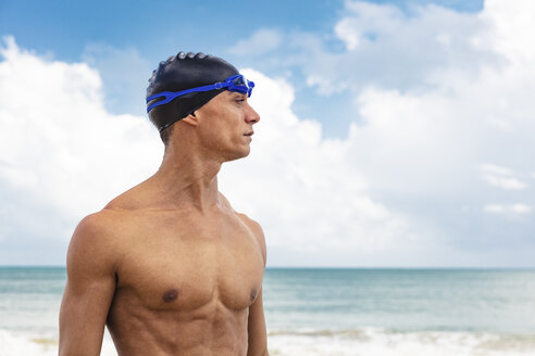 Muskulöser männlicher Schwimmer am Strand, der wegschaut - CUF09601
