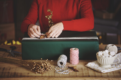 Frau wickelt Weihnachtsgeschenk ein, lizenzfreies Stockfoto