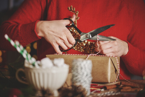 Frau wickelt Weihnachtsgeschenk ein, lizenzfreies Stockfoto