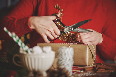 Frau wickelt Weihnachtsgeschenk ein - CUF09635