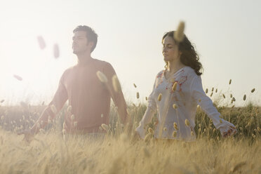 Couple holding hands in wheat field - CUF09645