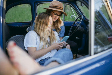 Freunde sitzen im Auto und benutzen ein digitales Tablet, Firenze, Toskana, Italien, Europa - CUF09671