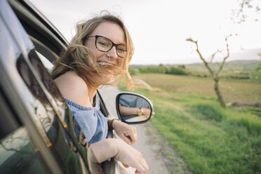 Young woman looking out of moving car window smiling, Firenze, Toscana, Italy, Europe - CUF09679