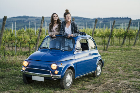 Touristen stehen durch das Schiebedach eines Autos, Weinberg, Toskana, Italien - CUF09685